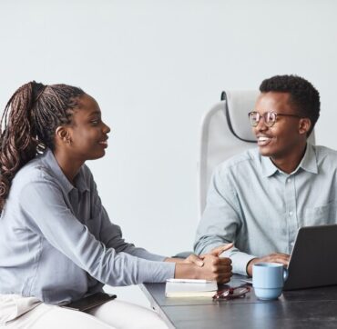 minimal-portrait-two-young-african-american-colleagues-collaborating-project-smiling-while-using-laptop-together-office-copy-space_236854-34281